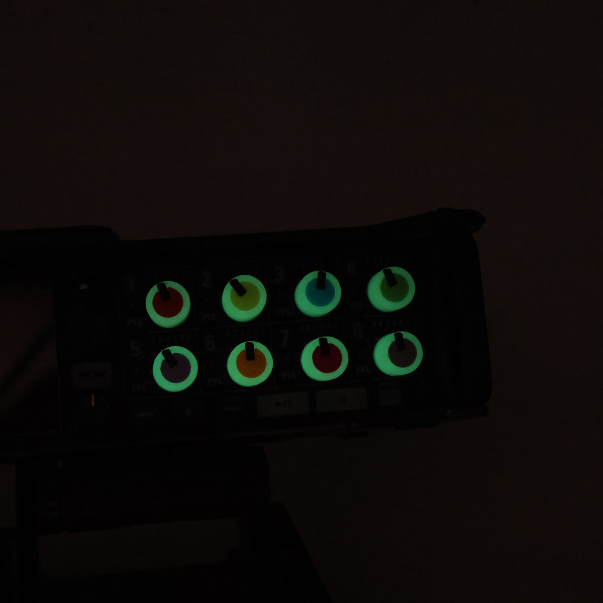 Control panel with glowing green buttons on a dark background