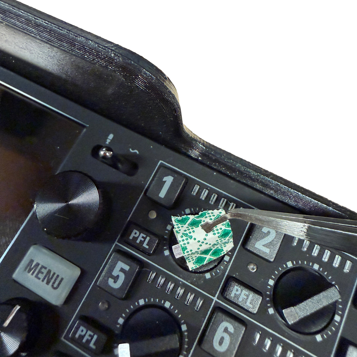 Close-up of a control panel with buttons and a small green circuit board.